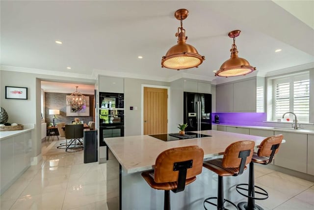 The sleek kitchen has a central island with breakfast bar.