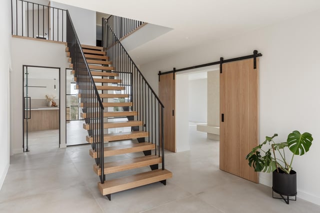 A feature staircase leads up to a gallery landing.