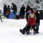 Children and their parents enjoying sledging down a hill in Harrogate back in 2010