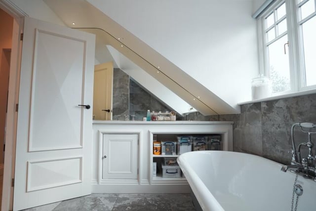 This bathroom, one of five in the house, features a free standing bath tub.