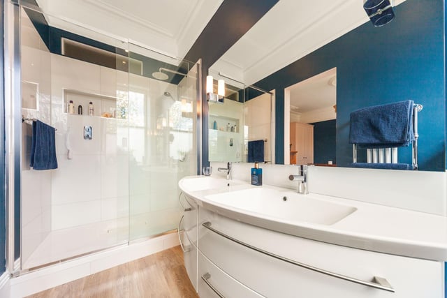 A contemporary en suite shower facility with twin washbasins.