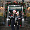 Here's to a successful time for Harrogate's hospitality trade - Yorkshire Hotel staff Anna Crisp and Sophie Bracewell pictured outside the festive-looking Pickled Sprout in December 2023. (Picture Gerard Binks)