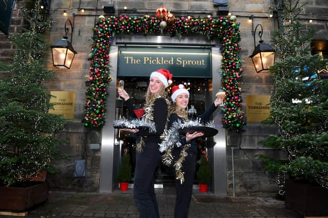 Here's to a successful time for Harrogate's hospitality trade - Yorkshire Hotel staff Anna Crisp and Sophie Bracewell pictured outside the festive-looking Pickled Sprout in December 2023. (Picture Gerard Binks)