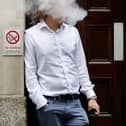A smoker is engulfed by vapours as he smokes an electronic vaping machine.