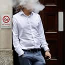 A smoker is engulfed by vapours as he smokes an electronic vaping machine.