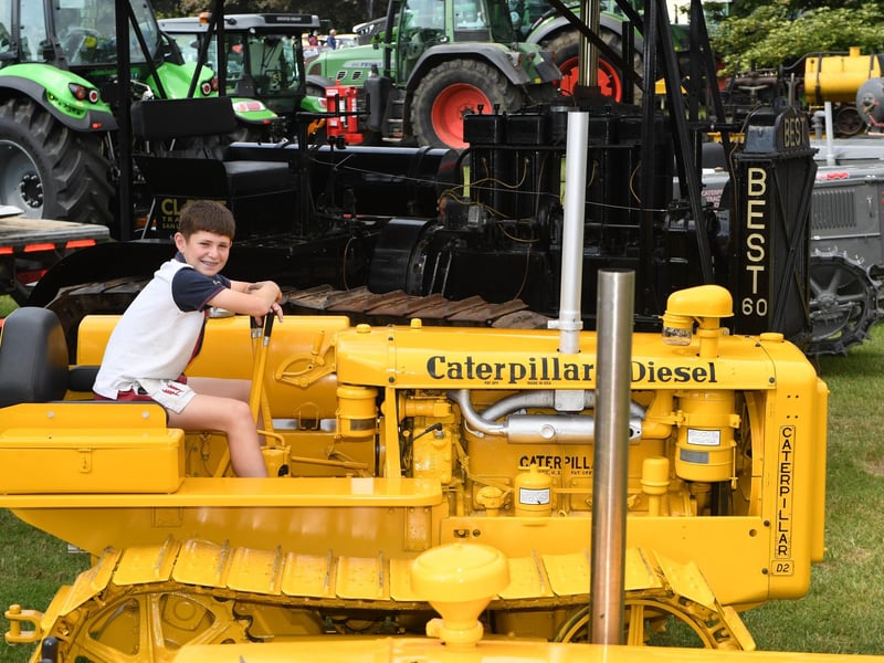 Joe Snowden (aged 13) sat on a Caterpillar Tractor in the sunshine at Newby Hall