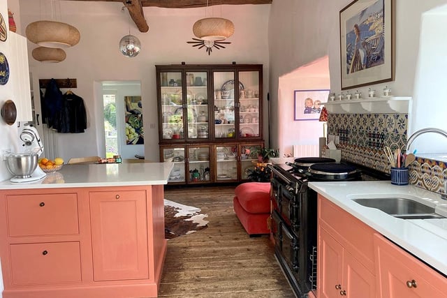 There are oak cabinets and a three-oven Aga in the kitchen, with windows looking over the valley.