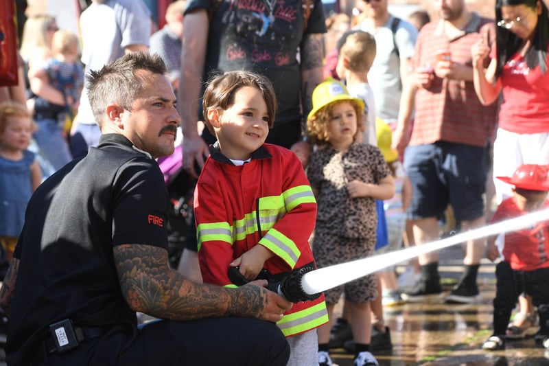 Umut Ayaz (aged five) enjoying having a play with a fire hose during a demonstration