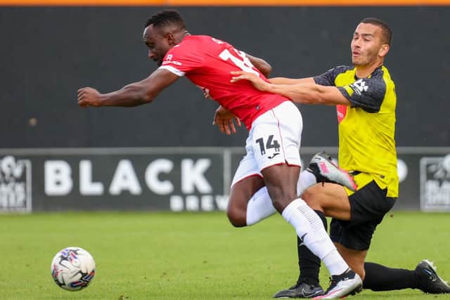 Rod McDonald challenges Morecambe's Jordan Slew during Saturday's League Two clash at Wetherby Road.