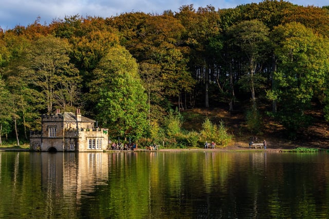 Autumn pictures around Newmillerdam, Wakefield. The Boathouse tearoom is reflected in the lake as the sun light shows off the turning colours of Autumn.