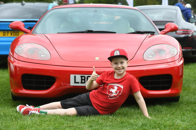 Jack Johnson (aged eight) from Scarborough with a red Ferrari on display at the show