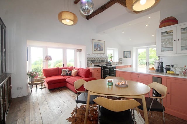 The cottage kitchen, with dining and family areas, has a vaulted ceiling and doors to the seating areas outside.