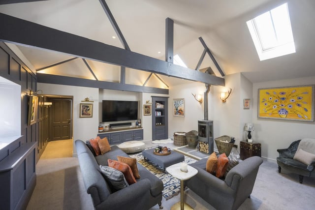 Open vaults to the ceiling and a log burner stove add a rustic warmth to this stylish sitting room.