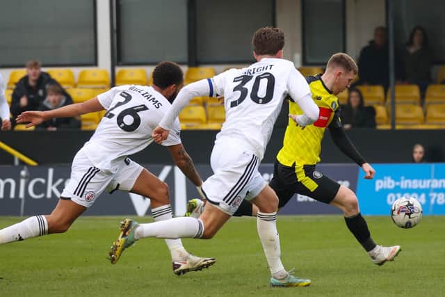 Harrogate Town's Matty Daly takes aim at the Crawley Town goal.