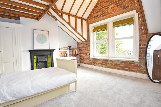 Beams and a feature wall with open brickwork add a rustic touch to this double room with fireplace.