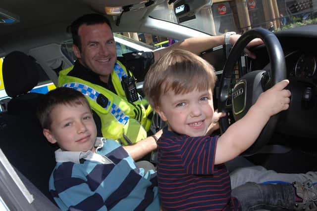 Harrogate's popular Sgt Paul Cording ,who receives the BEM for services to policing and to charity, is pictured here at a Police, Fire and rescue demo in Harrogate, Also pictured are youngsters Ben and Tom James. (Picture Adrian Murray)