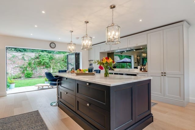 The modern kitchen is open plan to family and dining space, with bi-fold doors to an outside patio.