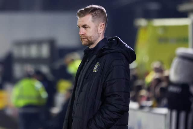 Harrogate Town manager Simon Weaver watches on from inside his technical area at Grimsby Town's Blundell Park.