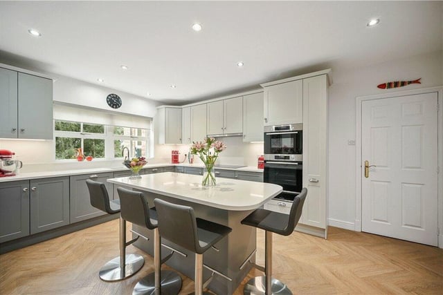 The spacious fitted kitchen has a central island unit with breakfast bar.