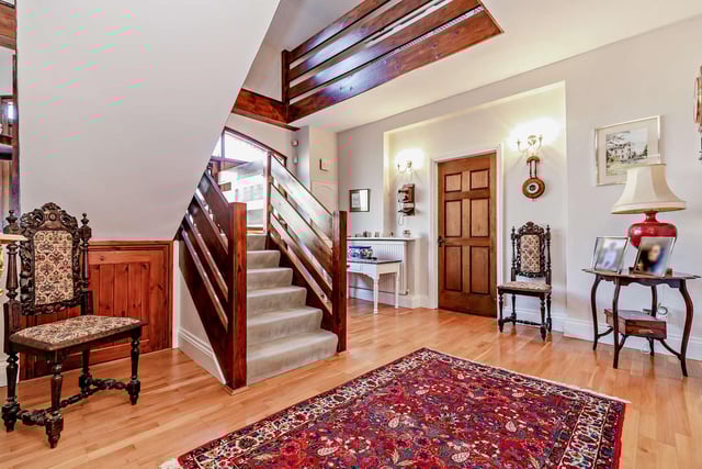 The entrance hall, with staircase up to a gallery landing, has an original hay winch as a feature.
