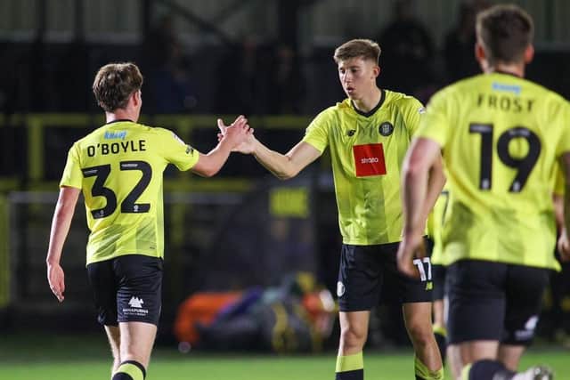 Harrogate Town midfielder Finn O'Boyle is congratulated on his debut goal by team-mate Josh Austerfield.