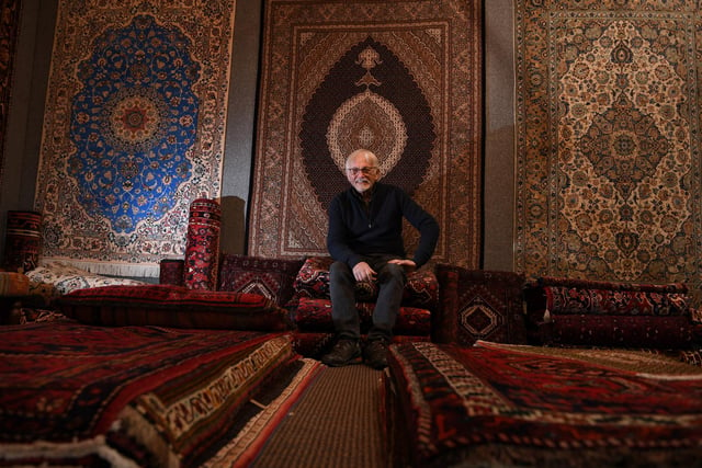 John Briggs, who is a Persian rug specialist, with a number of beautiful rugs that were on display at the fair