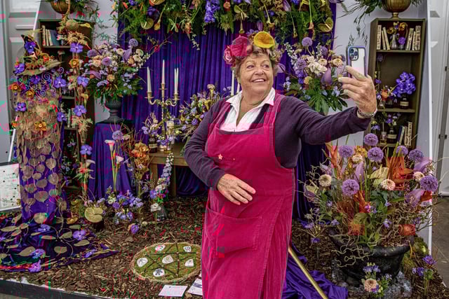 Sally Tompkins taking a picture with a beautiful display created by Wigan and Leigh College which was awarded Gold at the show