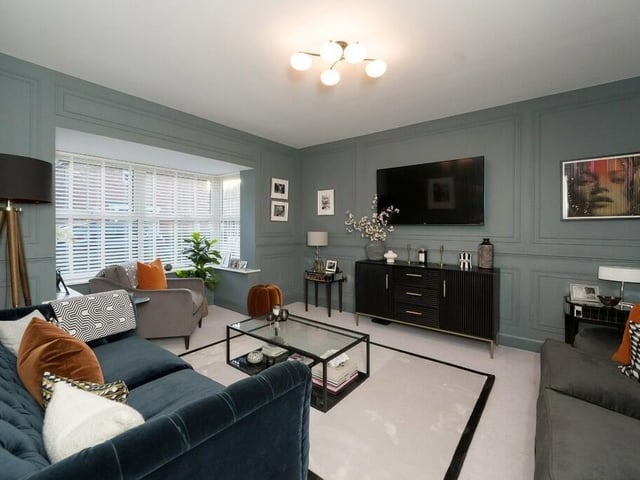 A sitting room with panelled wall design and walk-in bay window.