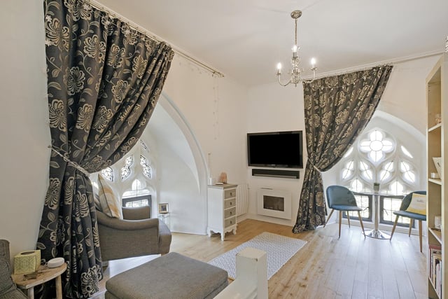 An open living area with beautiful feature arch windows, within The Clock Tower apartment.