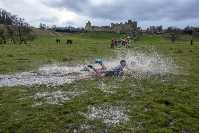 Players splashing through the puddles at the Alnwick Shrovetide football match.