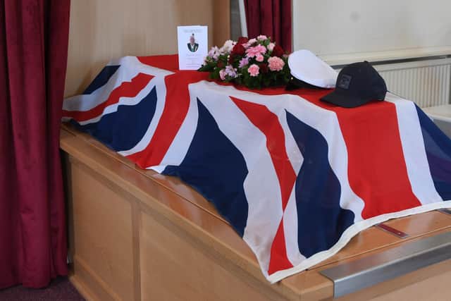 The coffin of D Day Veteran Maurice Hammond at Stonefall Crematorium in Harrogate with Union Jack flag, Royal Navy cap and his golf cap.