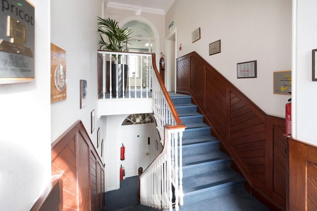 A panelled reception hall has a staircase leading up to the first floor.