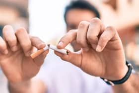 Two hands breaking a cigarette