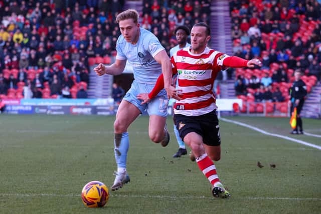 James Daly takes on Doncaster right-back Jamie Sterry during Saturday's League Two clash at the EcoPower Stadium.