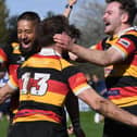 Harrogate RUFC's Richie Kaisia, left, and Pete Olley, right, congratulate team-mate Kristan Dobson after he completed his hat-trick of tries during Saturday's title-clinching victory over Driffield. Pictures: Gerard Binks