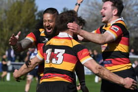 Harrogate RUFC's Richie Kaisia, left, and Pete Olley, right, congratulate team-mate Kristan Dobson after he completed his hat-trick of tries during Saturday's title-clinching victory over Driffield. Pictures: Gerard Binks