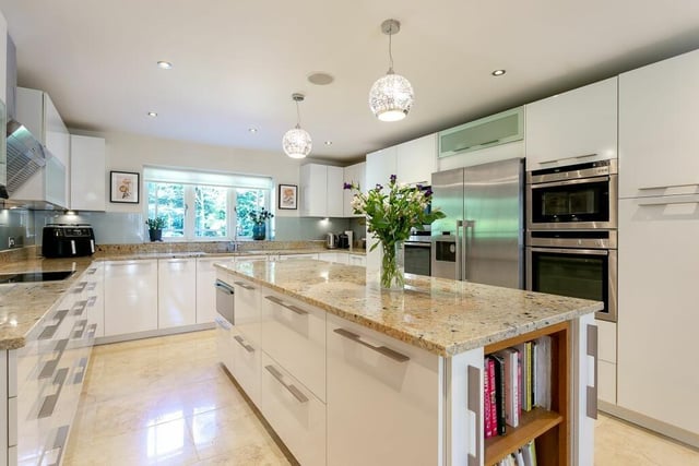 A fitted kitchen with granite worktops and a large central island.
