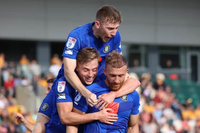 George Thomson is congratulated by Harrogate Town team-mates Matty and James Daly after opening the scoring during Saturday's League Two win at Newport County. Pictures: Matt Kirkham