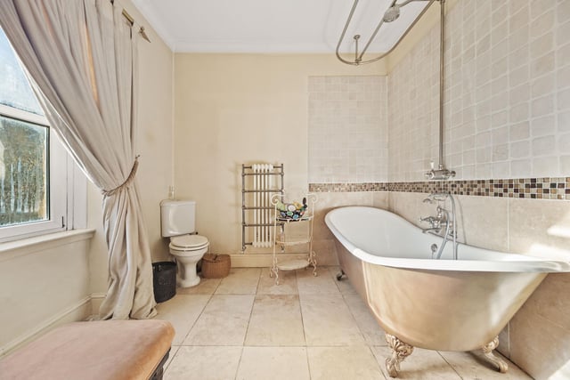 The en suite to the principal bedroom has a free-standing, roll-top bath with shower.