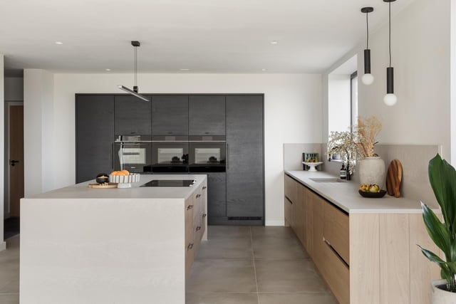 An ultra-modern kitchen is open plan to living and dining areas.