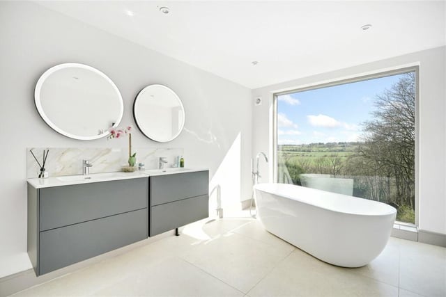 Relax in this bath with a view - one of the four bathrooms within the property.