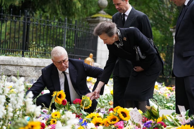 Prince Andrew, Duke of York, Edward, Earl of Wessex and Princess Anne, Princess Royal look at messages and floral tributes left by members of the public after attending a service at Crathie Kirk church near Balmoral following the death of Queen Elizabeth II. (Photo by Owen Humphreys-WPA Pool/Getty Images)