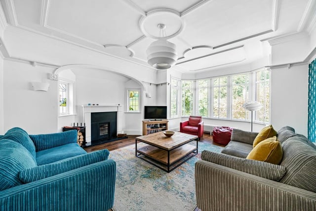 A distinctive lounge has a wide bay window and feature fireplace