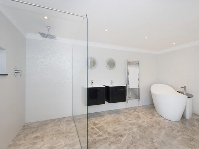 A contemporary style bathroom with twin washbasins.