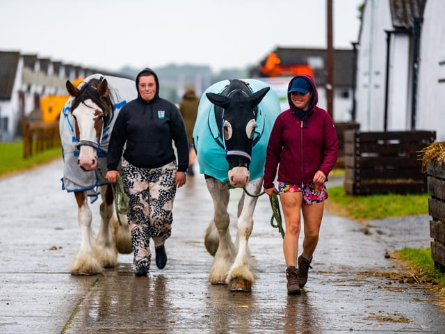 Ellah Roberts and Keely Gordon, walking in the rain with two Clydesdale from Cleish, Scotland