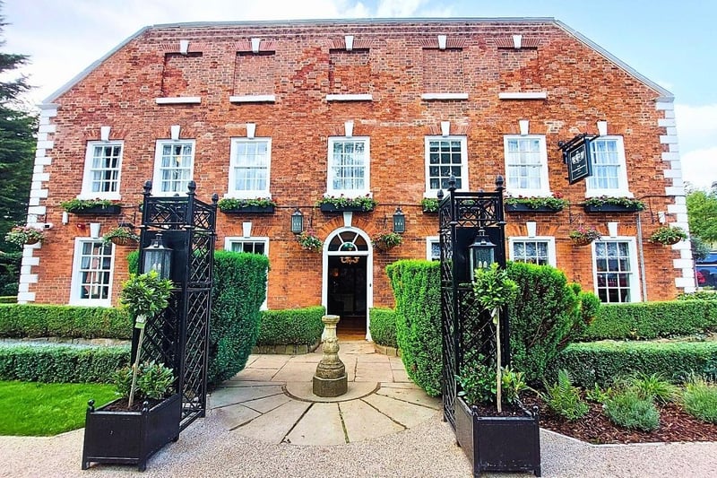 The newly transformed exterior of the building retains the sculpture, trees and bushes but no longer includes the moss.