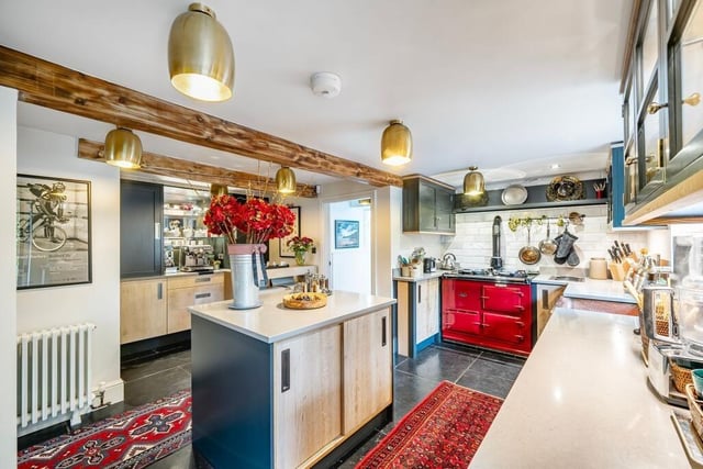 A contemporary, handbuilt breakfast kitchen, has an Aga, integrated appliances, and a barista bar.