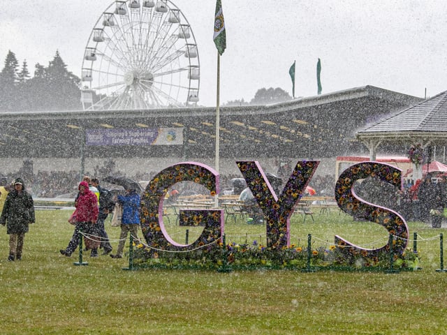A heavy downpour sends visitors running for cover on the first day of the show