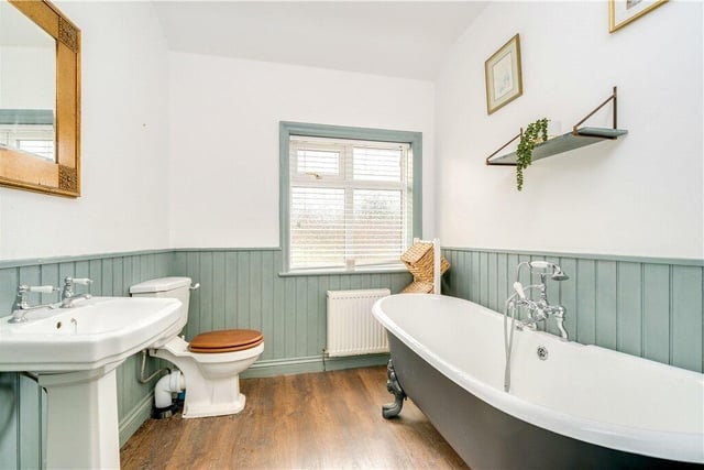The bathroom features tongue-and-groove panelling to the walls, and  a large, free-standing bath.