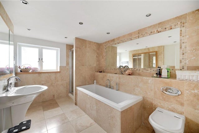 A stylish, tiled bathroom with bath and separate shower unit.